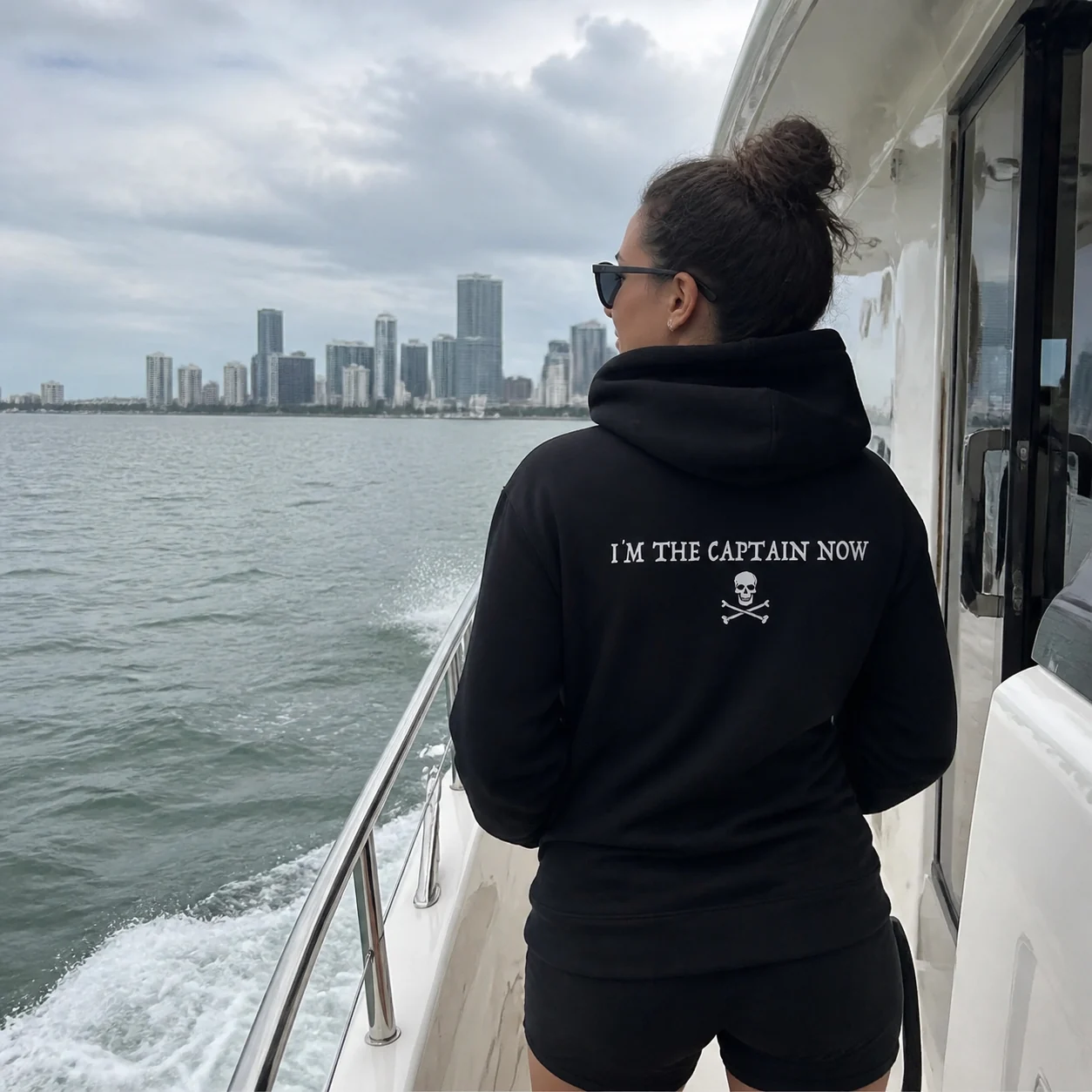 The black I'm The Captain Now hoodie worn on a yacht in Miami