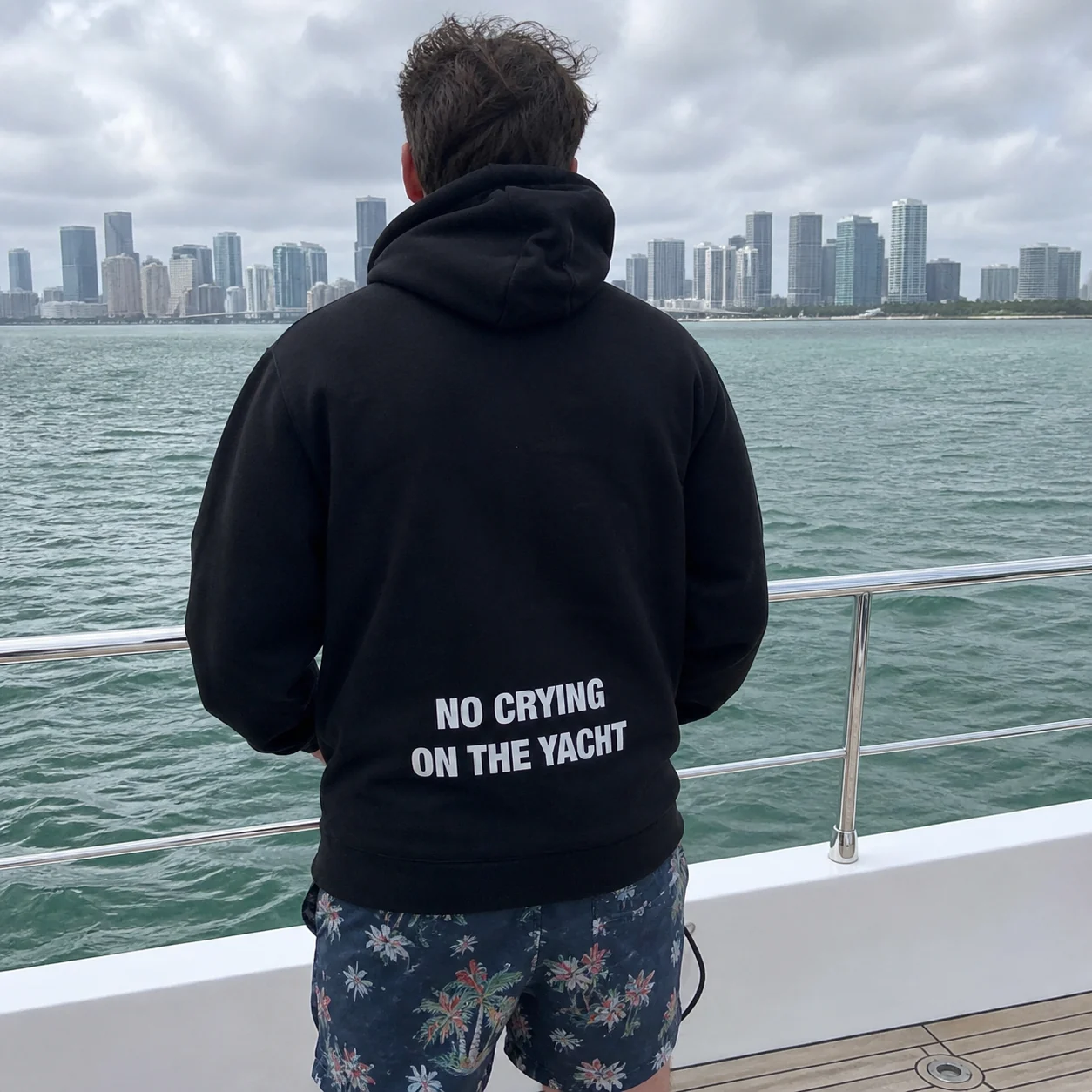 The black No Crying On The Yacht hoodie worn on a yacht in Miami