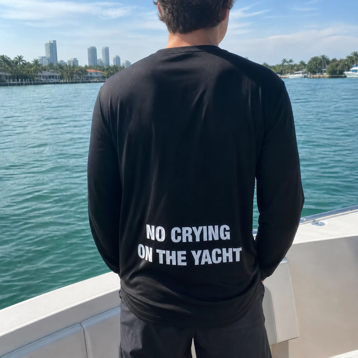 The black No Crying On The Yacht long-sleeve shirt worn on a yacht in Miami