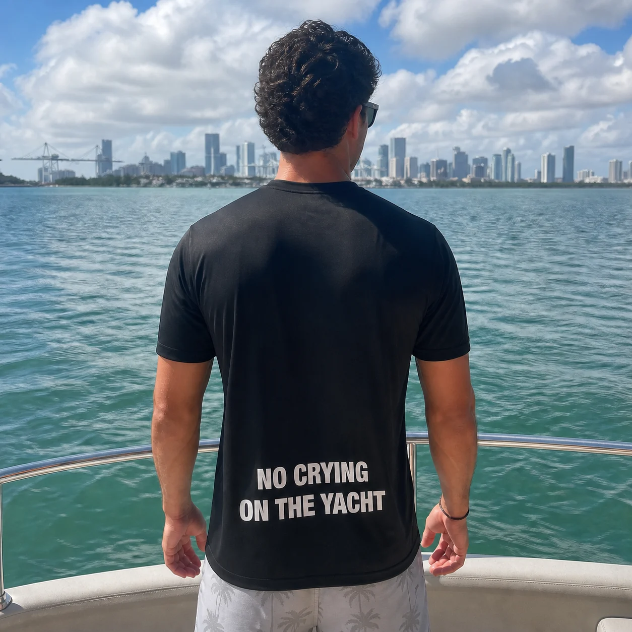 The black No Crying On The Yacht t-shirt worn on a yacht in Miami